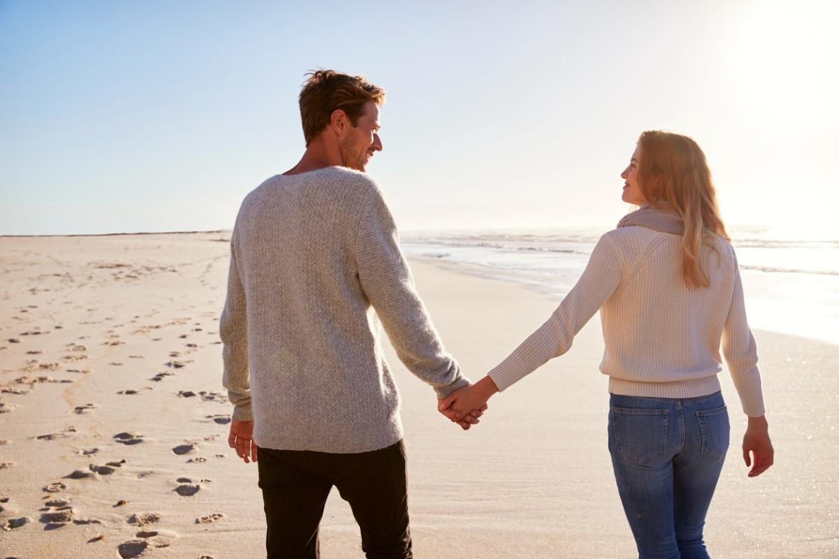 couple enjoying a walk on the beach during winter