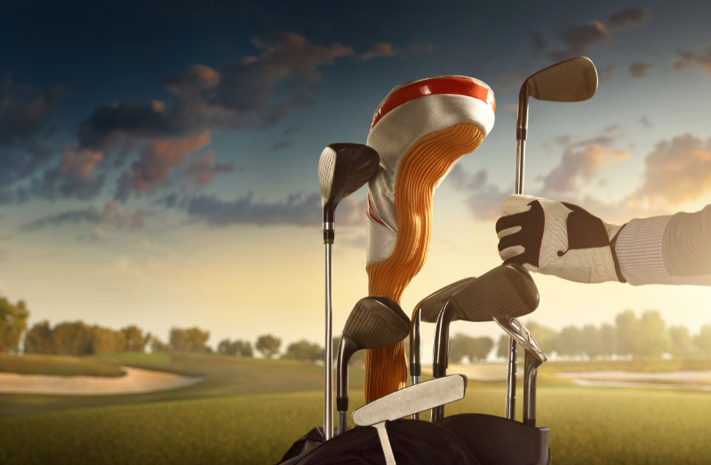 Image of a golf bag and clubs on a golf course